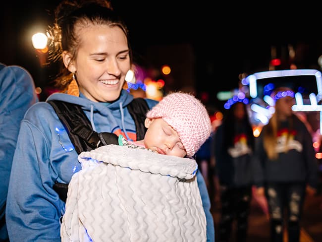 Rachael Camper holds her daughter, Cora, during the 2019 Colorado Springs Festival of Lights Parade. Cora is the wife of Asphalt and Paving District Blade Operator Garrett Camper.