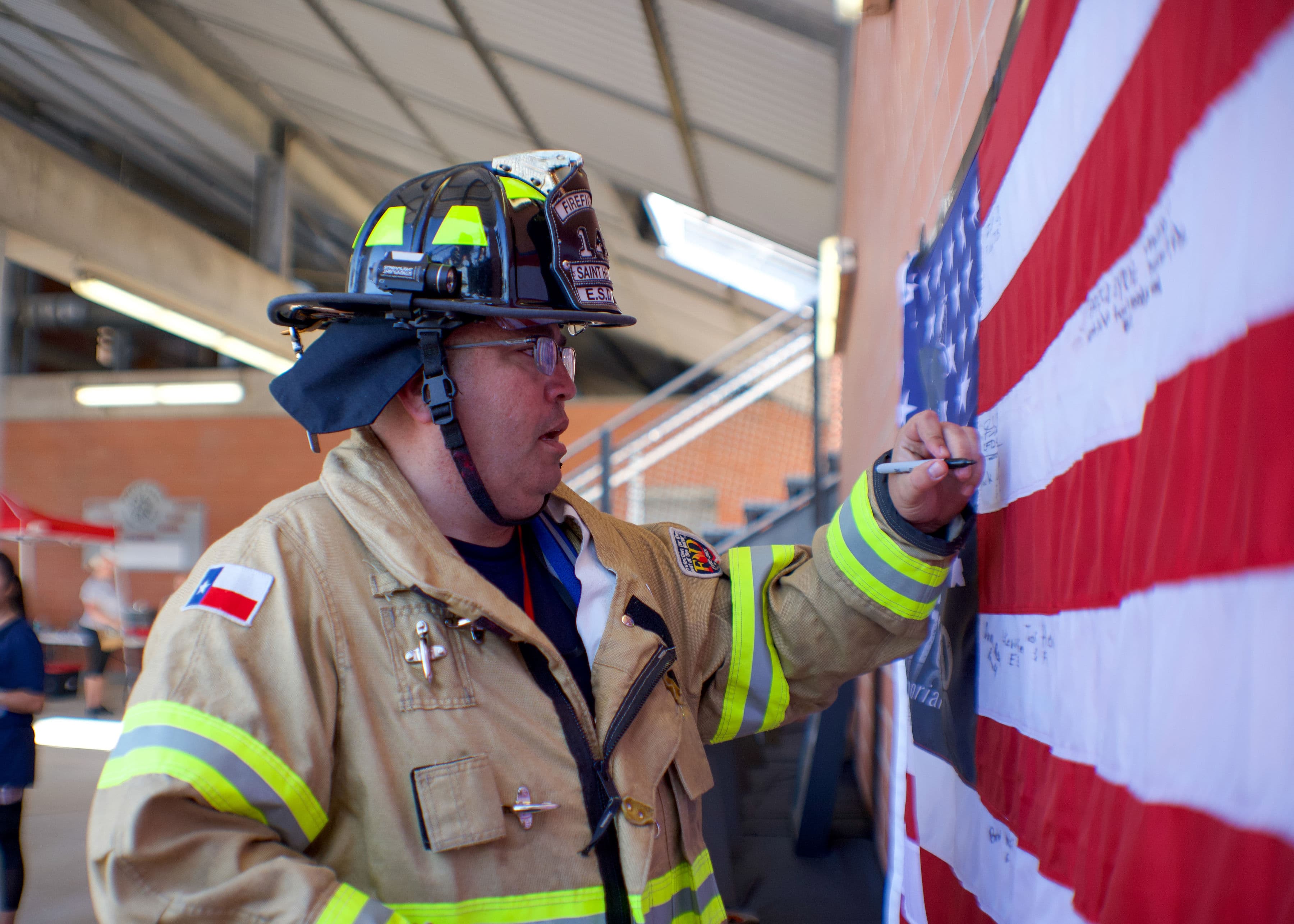 Ready Mix Operations Manager and Licensed Texas FirefighterJoe Ochoa signs an American Flag during the San Antonio 110 9/11 Memorial Climb on Sept. 11, 2021.