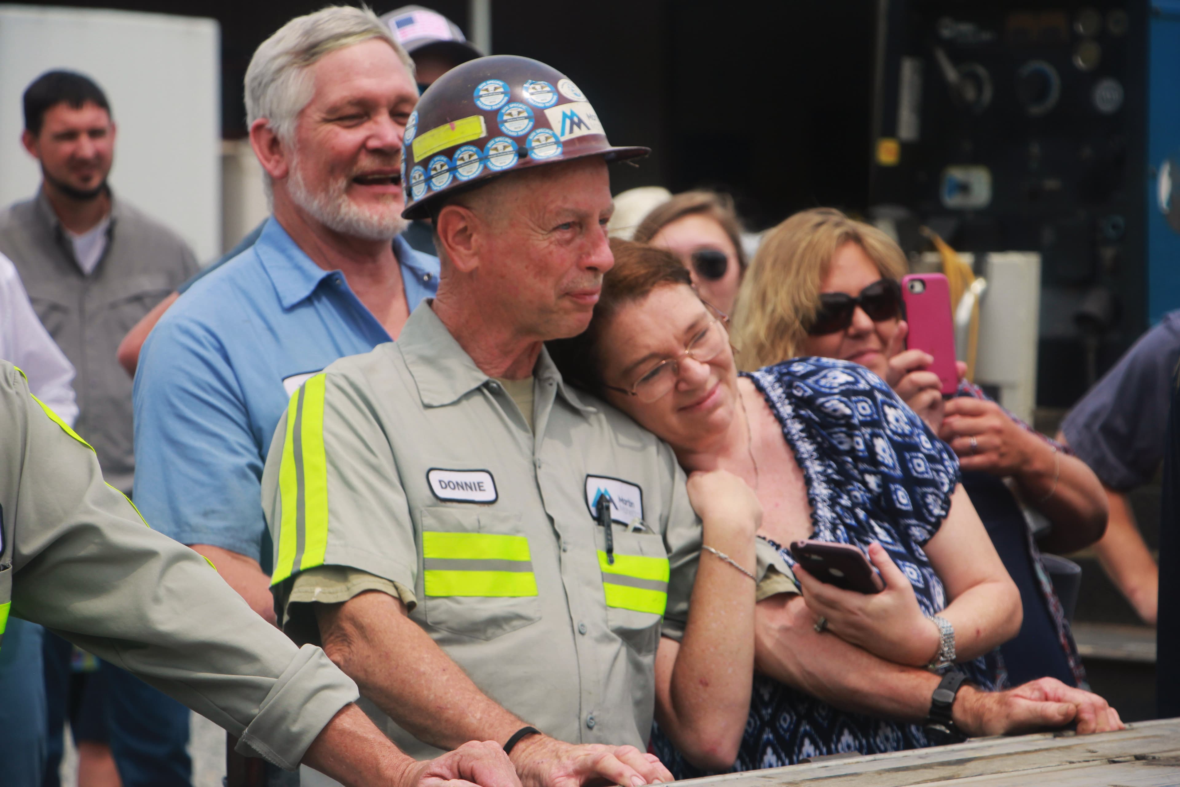 Kristen Barger hugs her husband as a helicopter lands outside the Salisbury Shop in North Carolina.