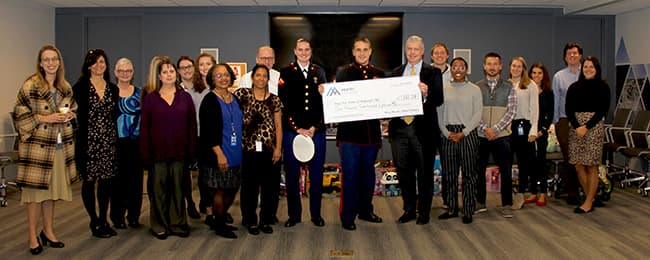Chairman and CEO Ward Nye and a team of Corporate Office and NC-East District employees deliver a check and 300 toys to the Raleigh Toys for Tots effort.