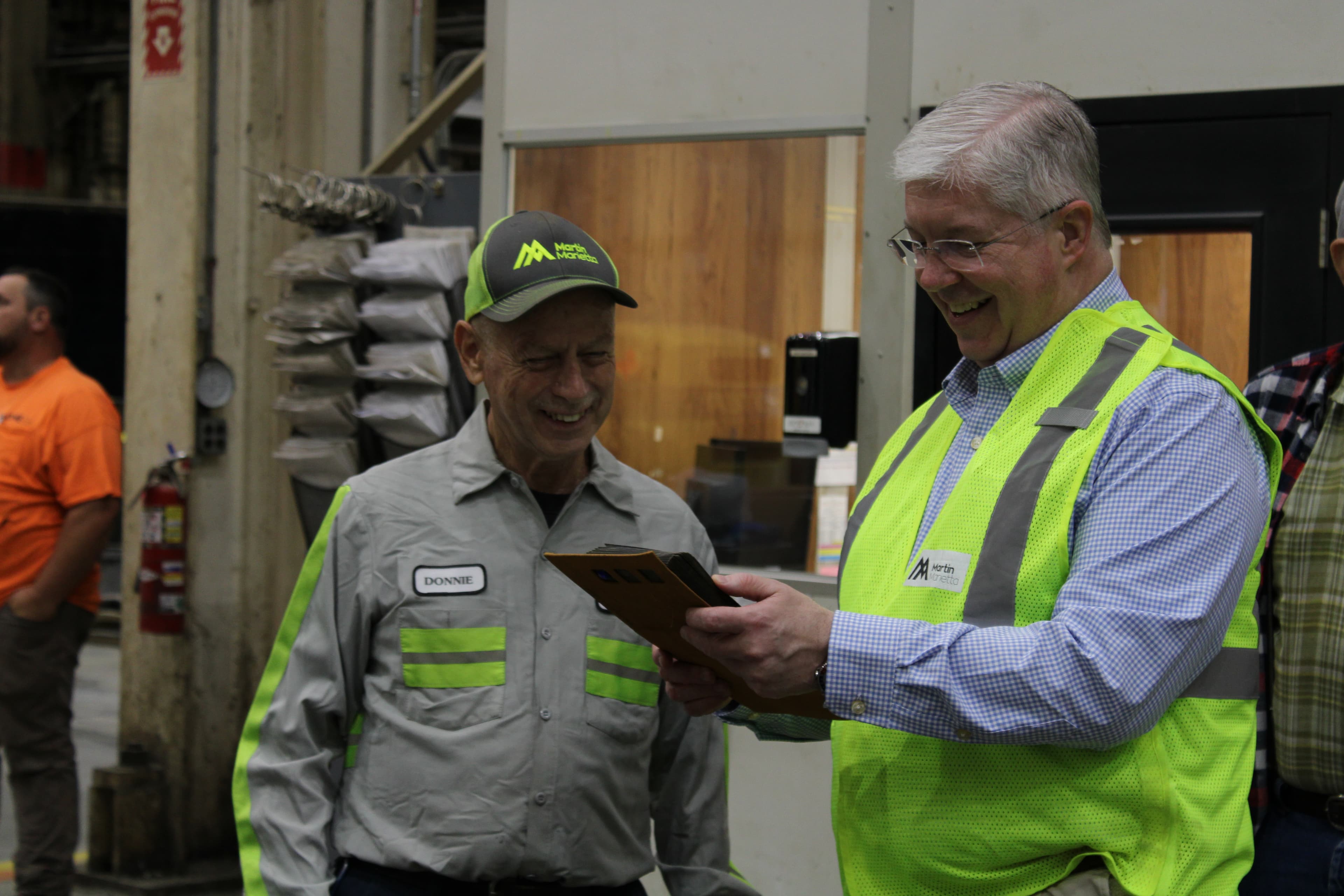 President and CEO Ward Nye (right) looks through retired driver Donnie Barger’s old photographs of Salisbury Shop during the site’s 60-year anniversary party