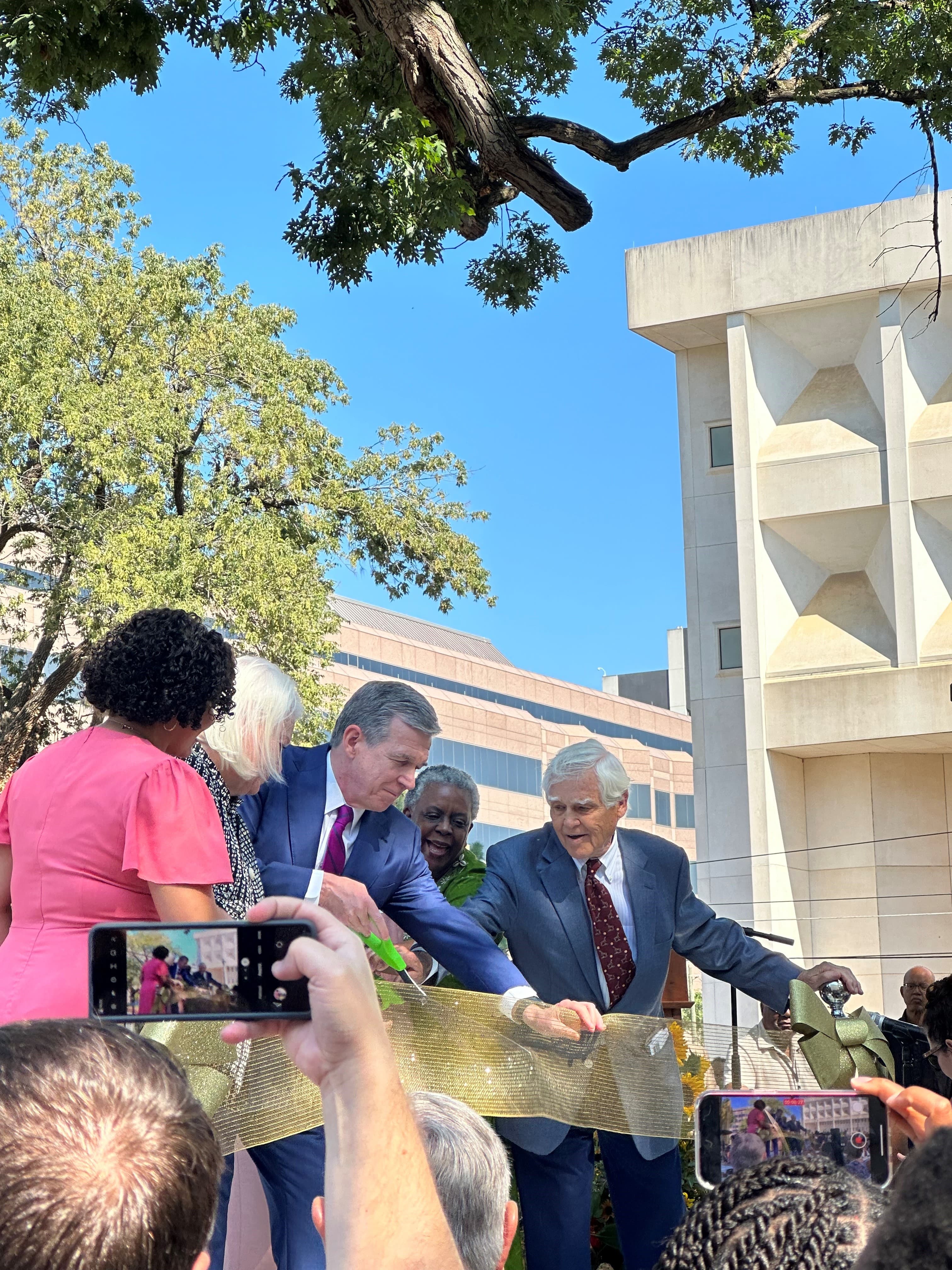 North Carolina Governor Roy Cooper (center), along with community members, cuts the ribbon on the newest park in the state’s capital.