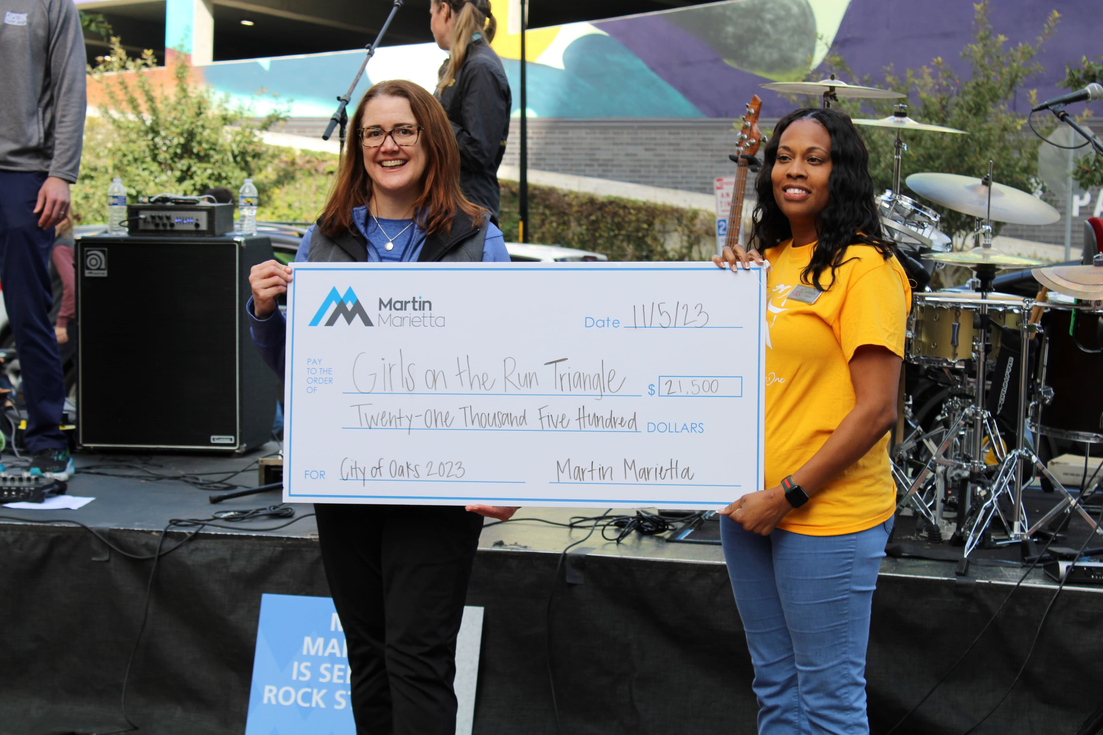 Martin Marietta’s Senior Vice President, Chief Human Resource Officer Kelly Bennett, left, presents a check to Girls on the Run Triangle’s Executive Director Aiesha Edwards after the marathon.