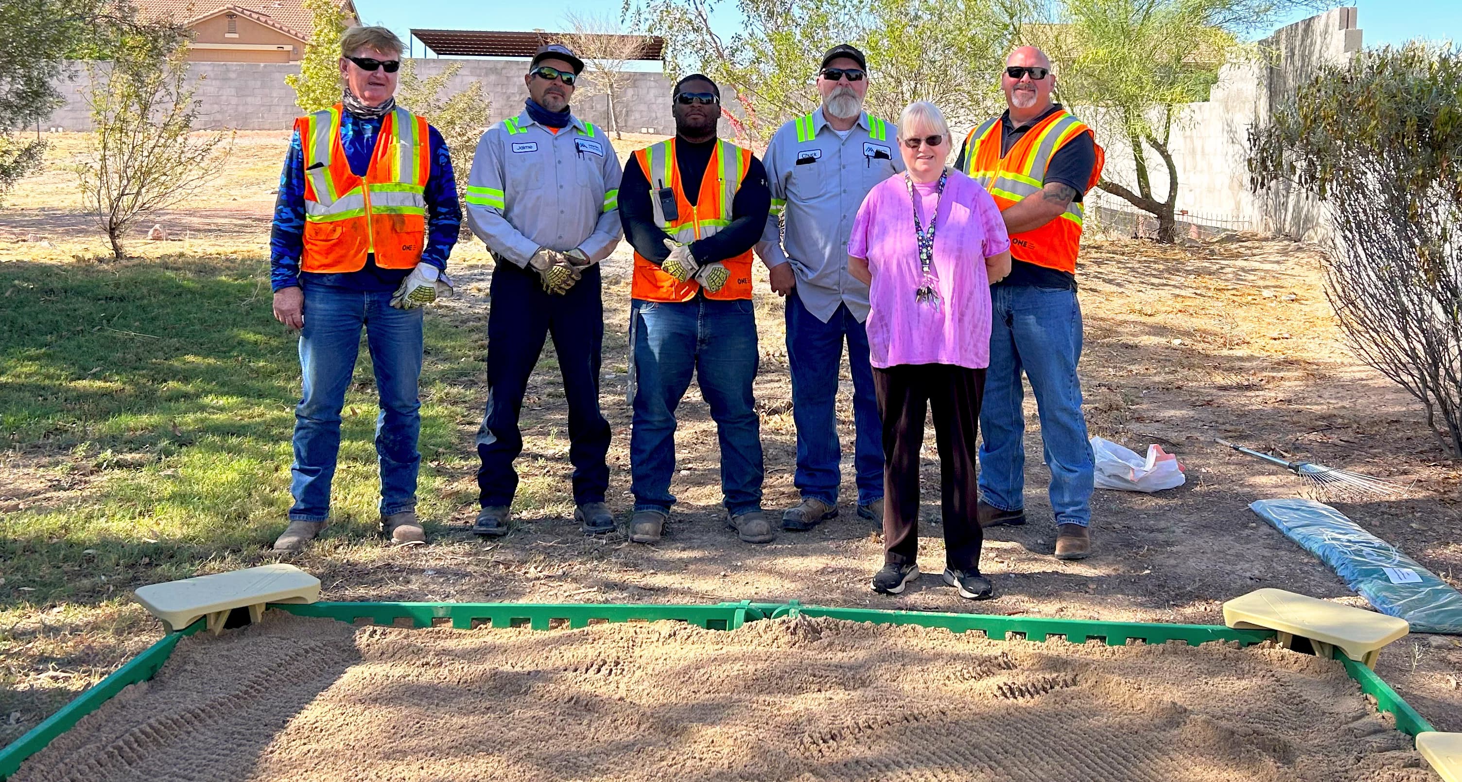 Chuck Trost, Jaime Rivas, Steve Trinci, Jon Frey, Janet Olson, Joe Fletcher and Maggie Smith work with Janet Olson of Natalie’s House to fill in a new sand box for victims of abuse.